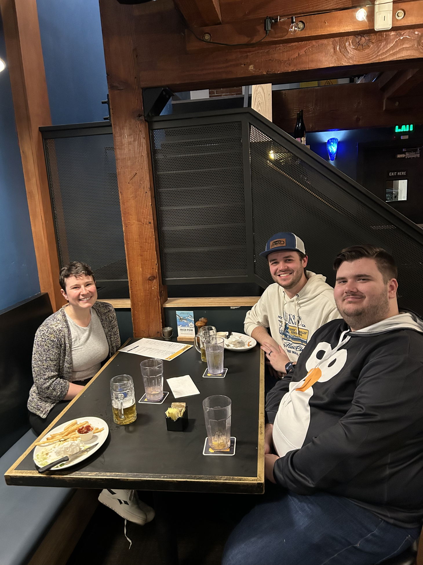 Sophia Bailey, Lucas Lemas, and Hunter Sensat sitting around table at a restaurant. 